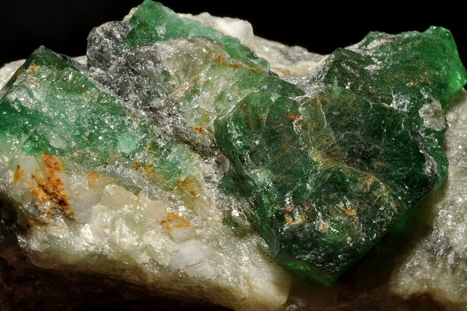 Close-up of green emerald crystals with inclusions in white host rock